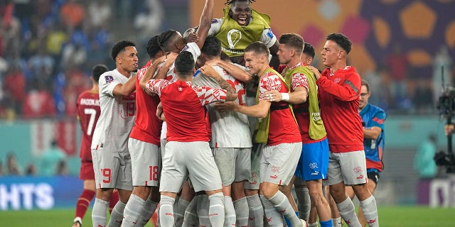 Switzerland's players celebrate their 3-2 win at the end of a World Cup Group G soccer match against Serbia at the Stadium 974 in Doha, Qatar, Saturday, Dec. 3, 2022.Â