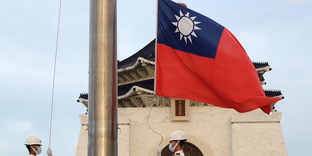 Two soldiers lower the national flag of Taiwan during the daily flag ceremony on the Liberty Square of Chiang Kai-shek Memorial Hall in Taipei, Taiwan, on July 30, 2022. 