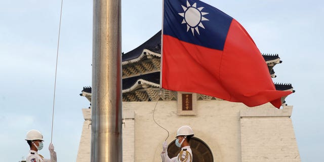 Two soldiers lower the national flag of Taiwan during the daily flag ceremony on the Liberty Square of Chiang Kai-shek Memorial Hall in Taipei, Taiwan, on July 30, 2022.