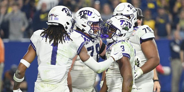 Emari Demercado #3 of the TCU Horned Frogs celebrates with teammates after rushing for a touchdown during the third quarter against the Michigan Wolverines in the Vrbo Fiesta Bowl at State Farm Stadium on December 31, 2022 in Glendale, Arizona. 