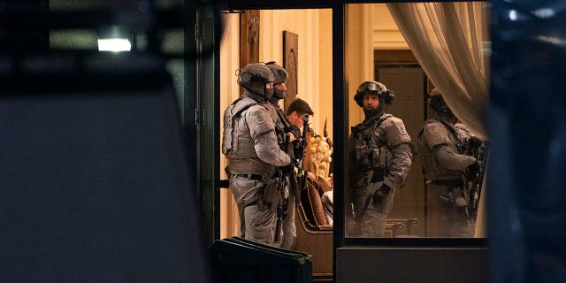 York Regional Police tactical officers stand in the lobby of a condominium building in Vaughan, Ontario, Sunday, Dec. 18, 2022. Police said multiple people are dead, including the suspect, after a shooting in a unit of the building.
