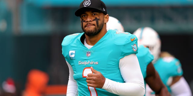 Tua Tagovailoa of the Miami Dolphins jumps onto the field before a game against the Green Bay Packers at Hard Rock Stadium on December 25, 2022 in Miami Gardens, Florida.