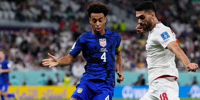 Tyler Adams of the United States, left, tries to block Iran's Ali Karimi during the World Cup Group B match at Al Thumama Stadium in Doha, Qatar, Nov. 29, 2022.
