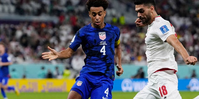 Tyler Adams of the United States, left, tries to block Iran's Ali Karimi during the World Cup Group B match at Al Thumama Stadium in Doha, Qatar, Nov. 29, 2022.