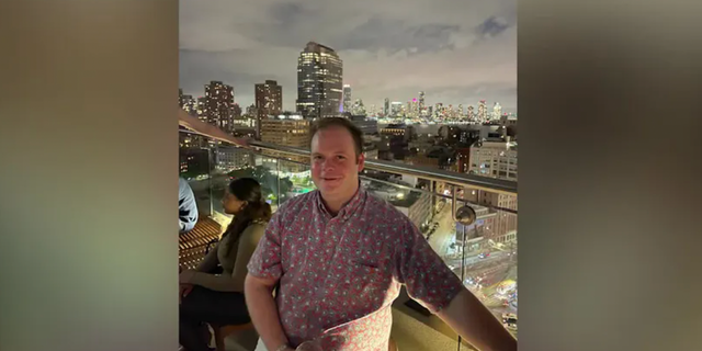 John Umberger poses on a city balcony