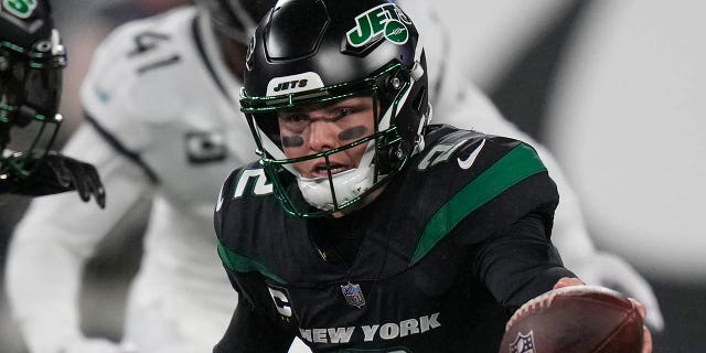 New York Jets quarterback Zach Wilson (2) hands off the ball to New York Jets running back Michael Carter (32) during the first quarter of an NFL football game against the Jacksonville Jaguars, Thursday, Dec. 22, 2022, in East Rutherford, N.J.