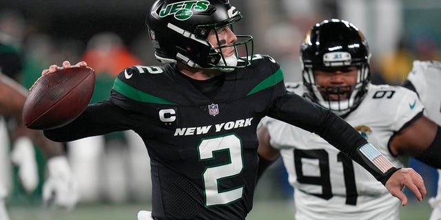 El mariscal de campo de los New York Jets, Zach Wilson (2), pasa contra los Jacksonville Jaguars en el primer cuarto de un partido de fútbol americano de la NFL, el jueves 22 de diciembre de 2022, en East Rutherford, Nueva Jersey. 