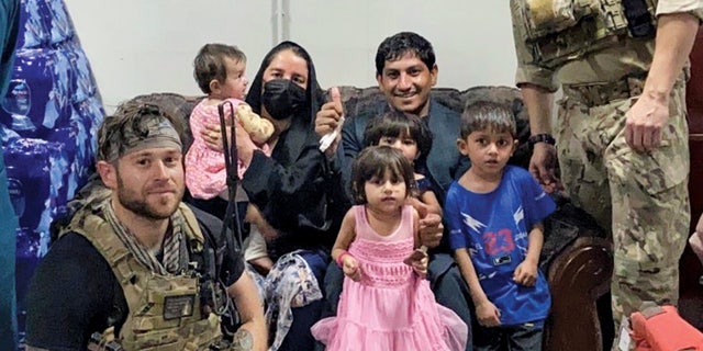 Zak and his family pose for a photo after being let into Hamid Karzai International Airport during the August 2021 evacuation.