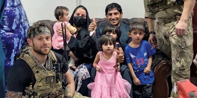 Zak and his family pose for a photo after being let into Hamid Karzai International Airport during the August 2021 evacuation.