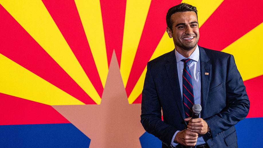 Abe Hamadeh in front of the flag of Arizona