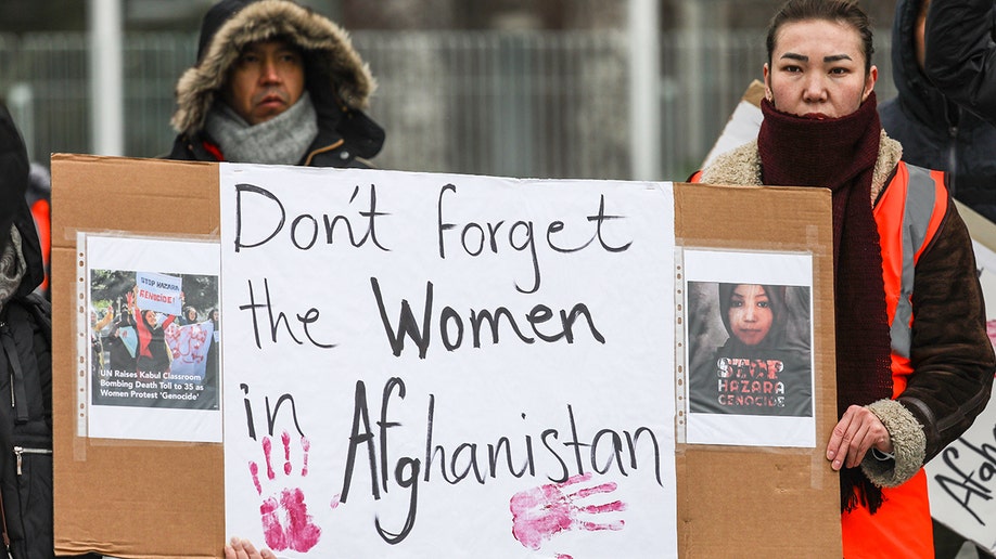 An Afghan woman holding a sign