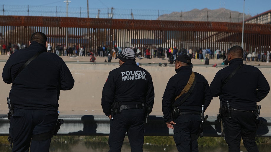 Border officials looking at migrants