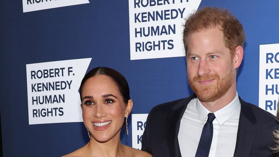Meghan Markle smiles next to husband Prince Harry on red carpet