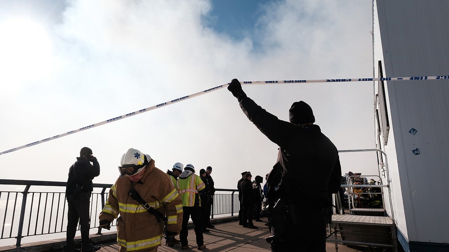 An official holding caution tape for firefighters