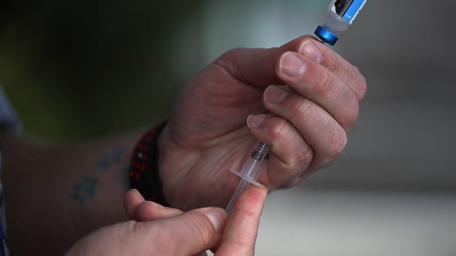 Syringe drawing a vaccine