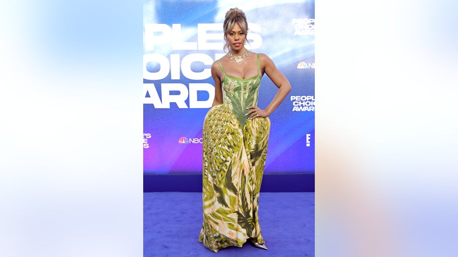 Laverne Cox wears green dress on red carpet.