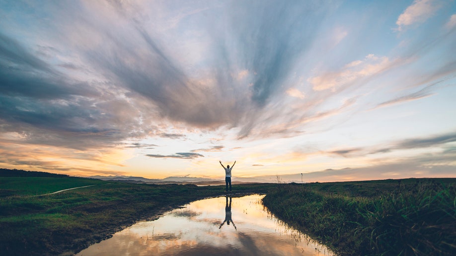 joven reflejado en un charco al atardecer