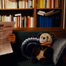 Benedict reading a newspaper with a teddy bear