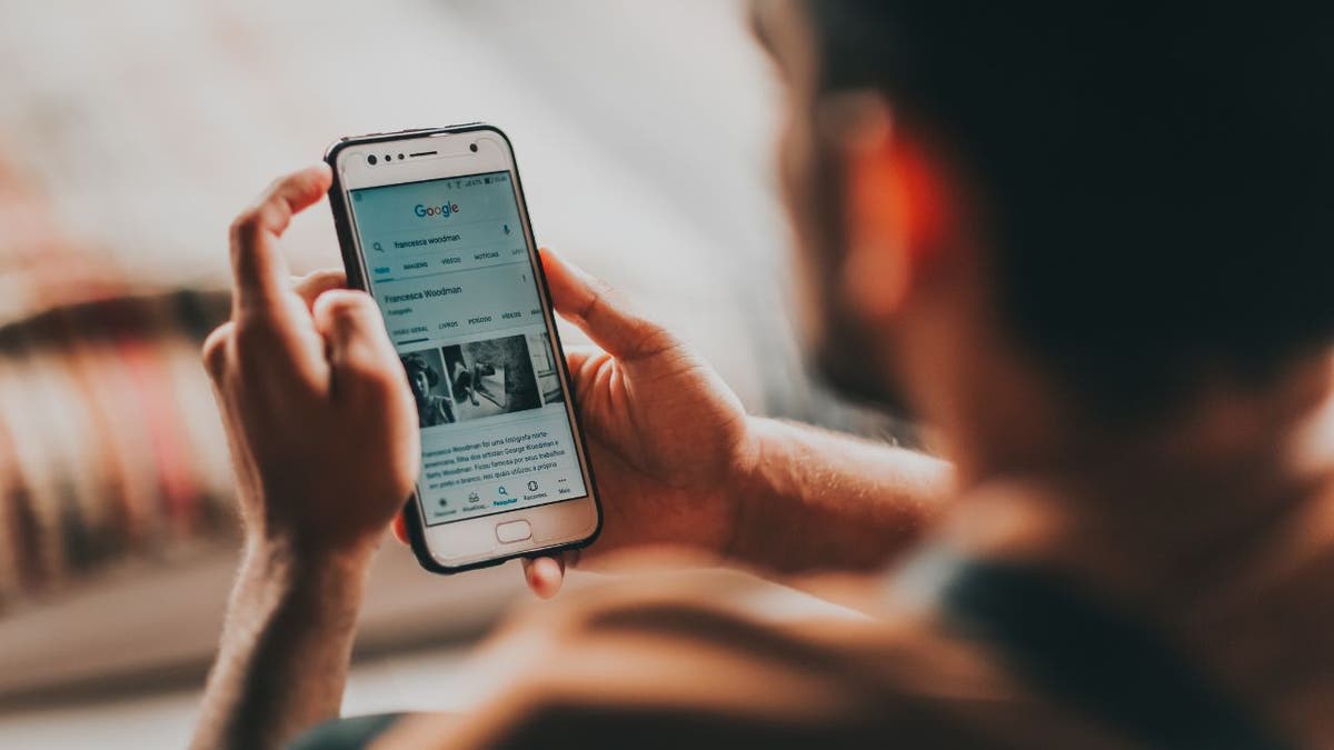 man searching google on iphone