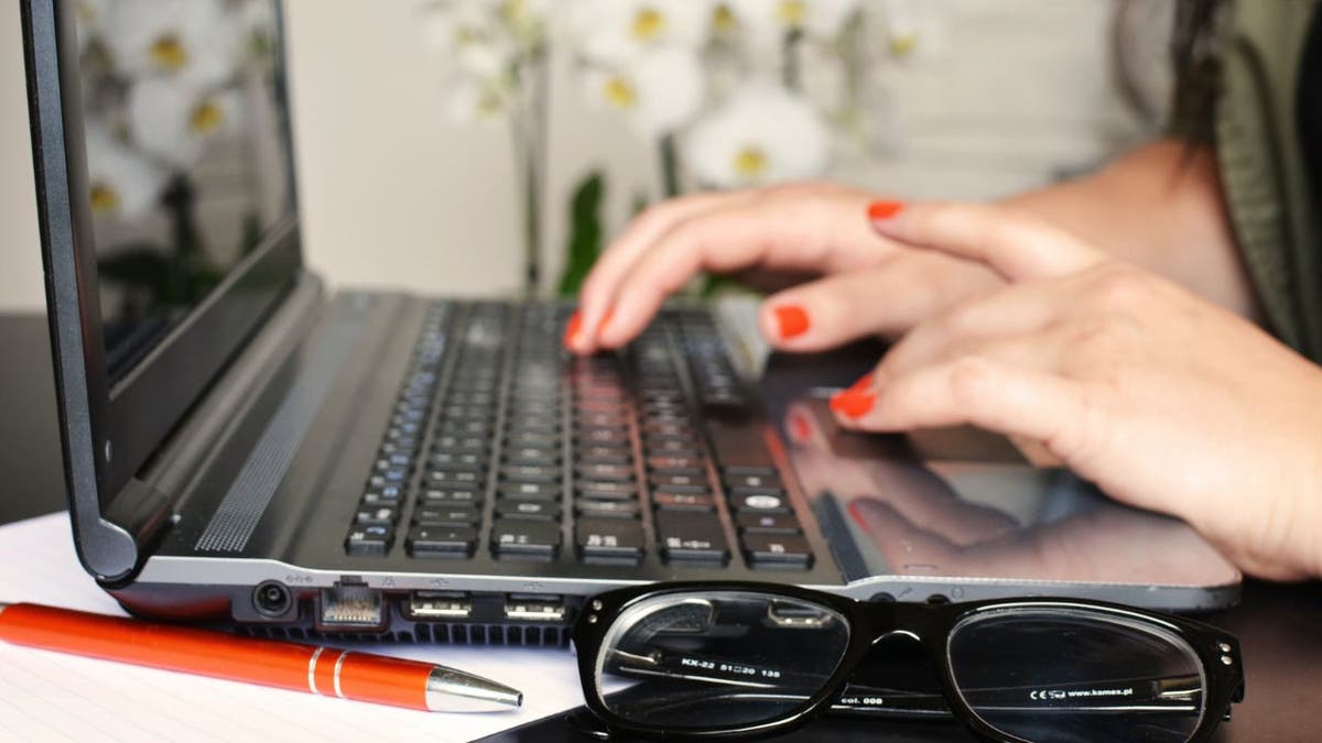 Woman types on her laptop keyboard