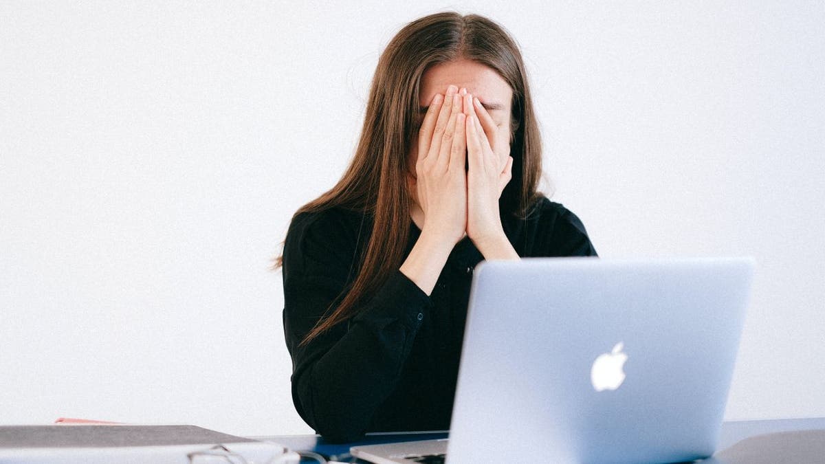 stressed woman at macbook laptop
