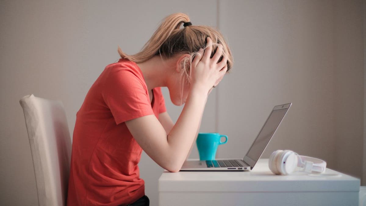 Woman looks worried while at her computer