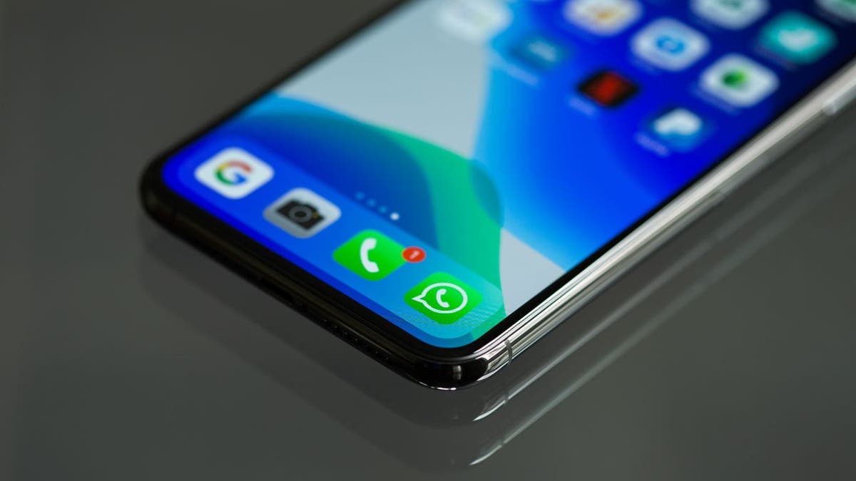 Zdjęcie z niskiego kąta przedstawiające ekran iPhone'a z widocznymi ikonami telefonu i Whatsapp