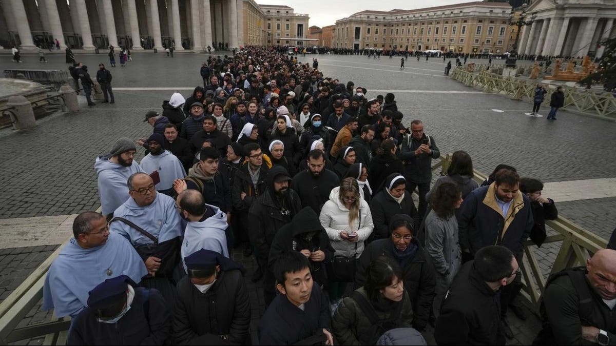 People wait in line to see Pope Benedict's body