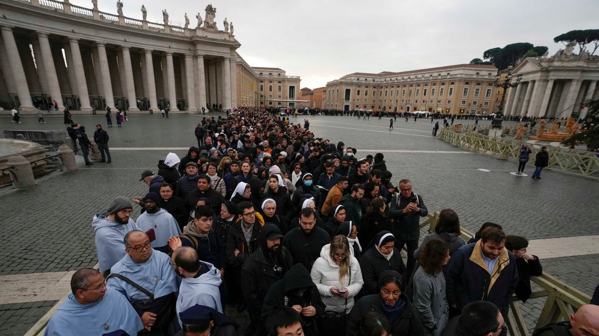 People wait in line to see Pope Benedict's body