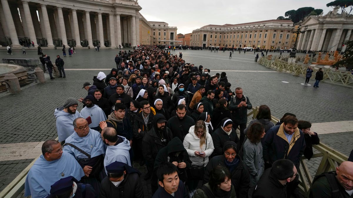 People wait in line to see Pope Benedict's body