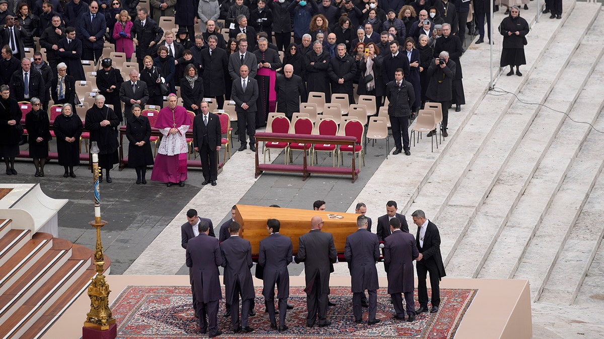 A photo of the coffin and people at the funeral