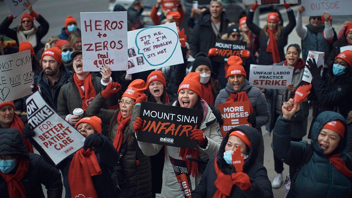 nurses hold signs reading 'mount sinai unfair'