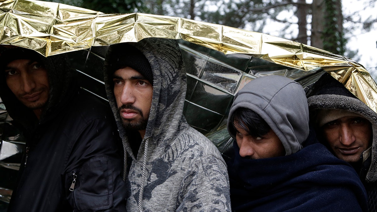 Migrants under a metallic space blanket