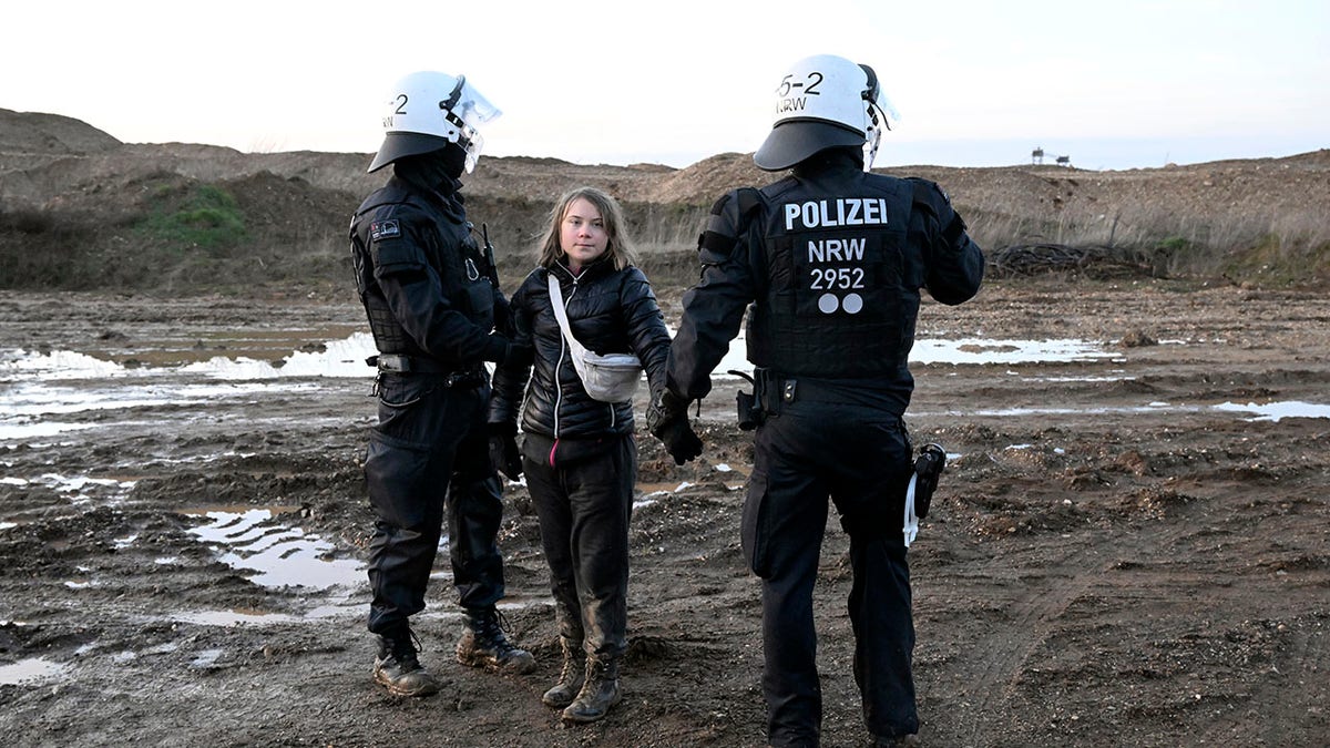 Greta Thunberg stands with officers