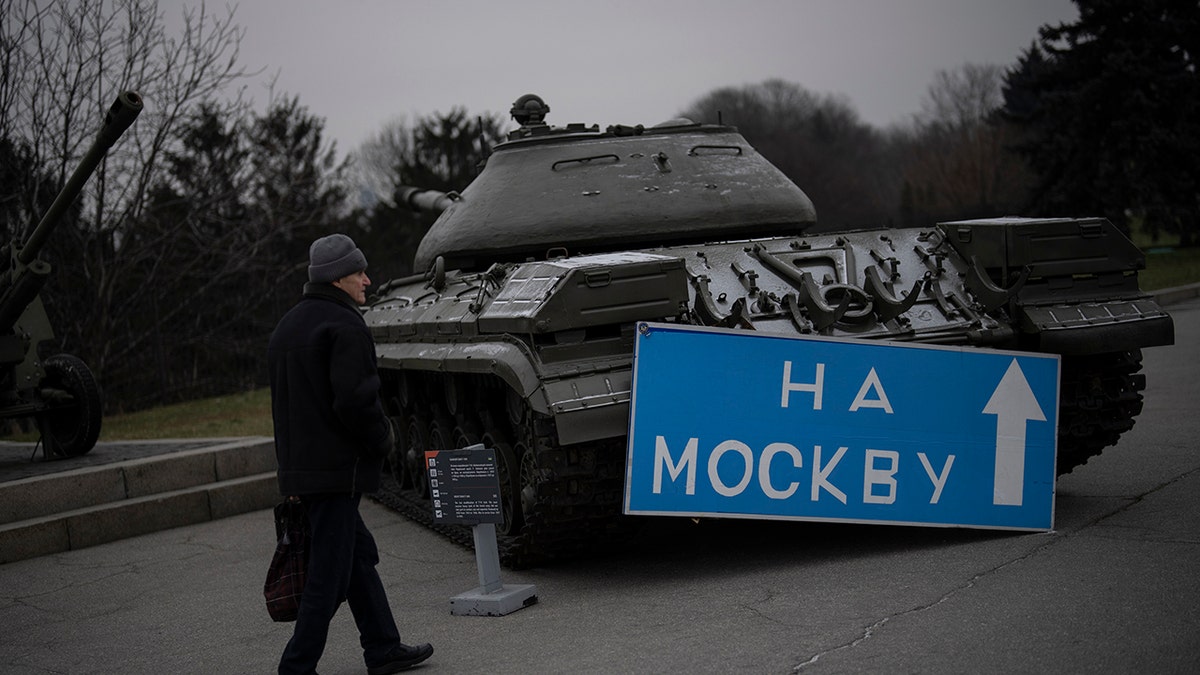 A person walking by a tank