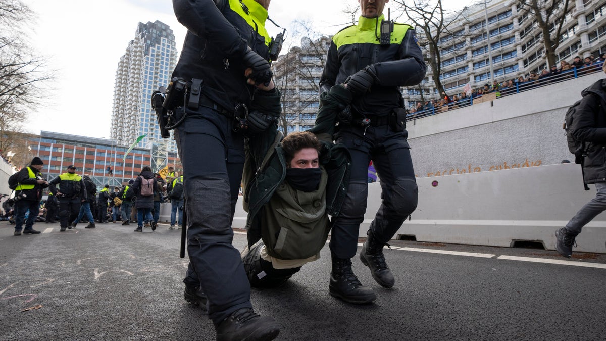 Climate change protesters in The Hague block highway, get detained and hauled away by bus