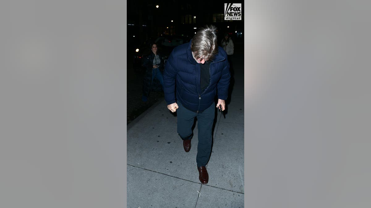 Alec Baldwin keeps his head down as he walks along the sidewalk