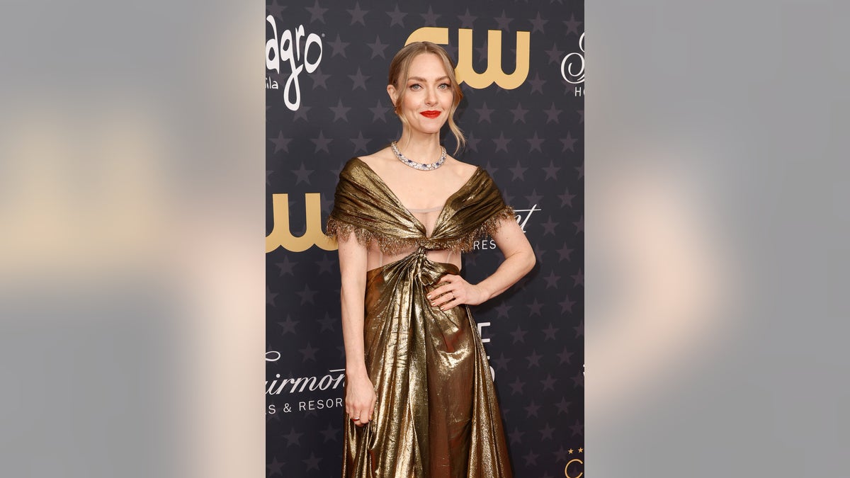 Amanda Seyfried poses in cut-out gold gown at Critics Choice awards
