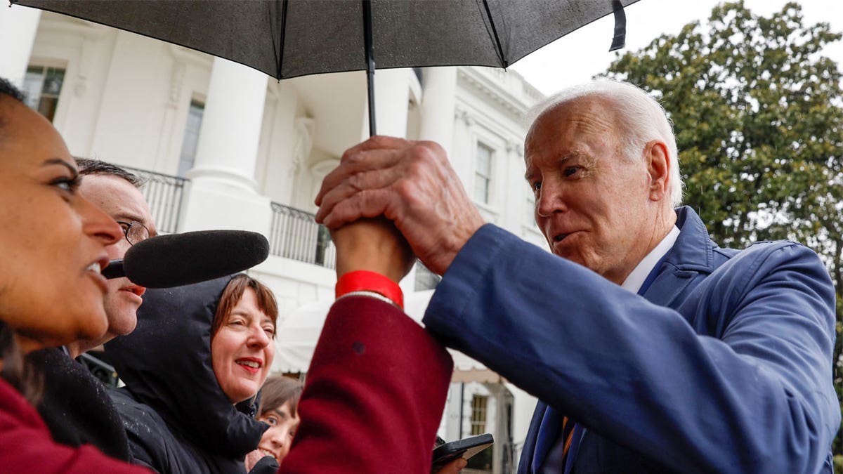 Biden holds Kristen Welker's hand