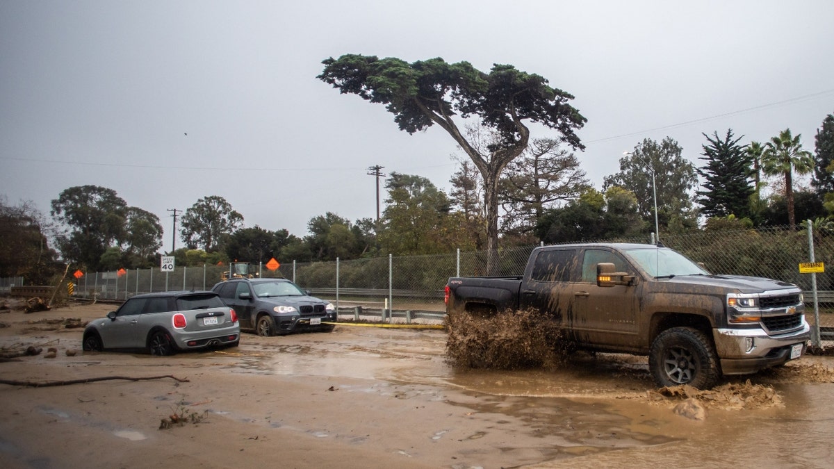 A truck tows a car that got stuck in the mud in Montecito, Calif.