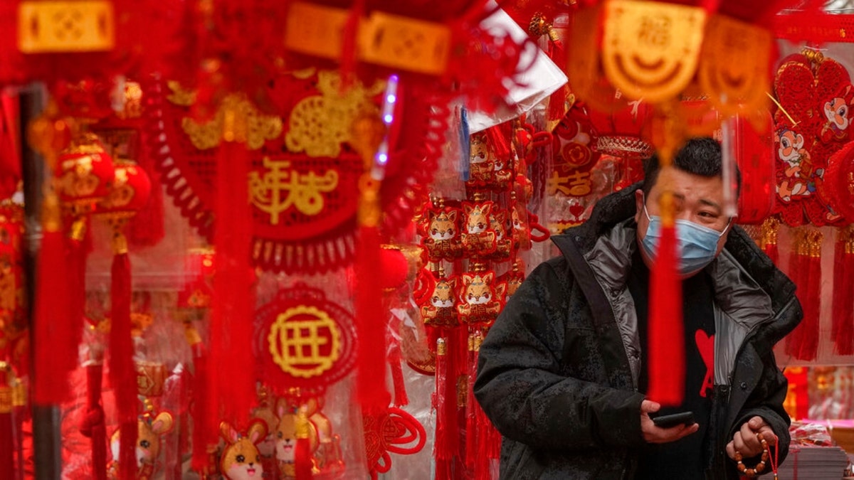 A man wearing a face mask shops for Chinese Lunar New Year