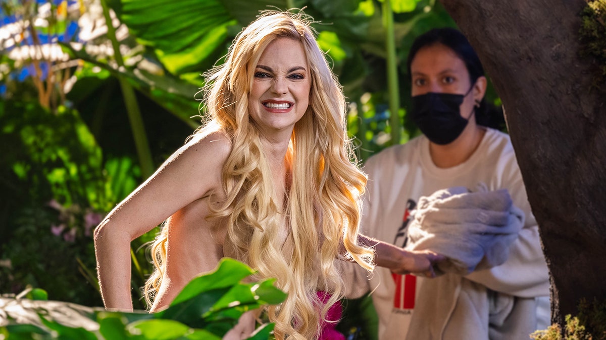 Anna Faris grins on set of her new advertisement for Avocados from Mexico with someone wearing a mask in the background