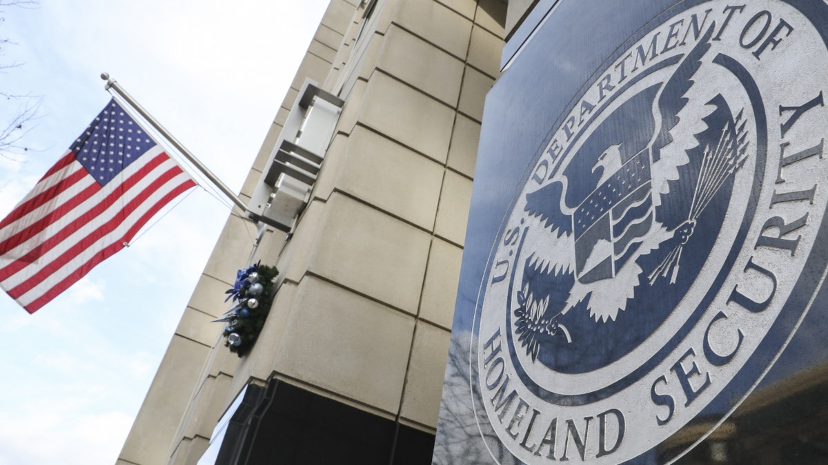 homeland security logo on building, US flag at left