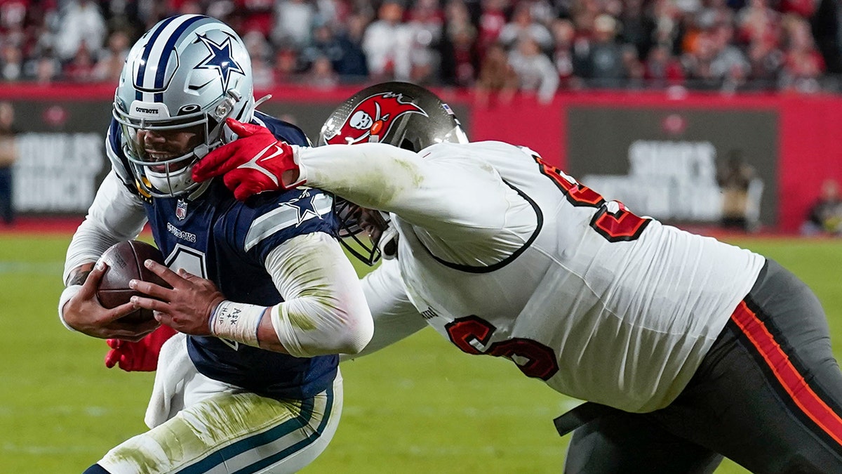 Tampa Bay Buccaneers defensive end Akiem Hicks (96) tries to tackle Dallas Cowboys quarterback Dak Prescott (4) during the first half of an NFL wild-card football game, Monday, Jan. 16, 2023, in Tampa, Fla.