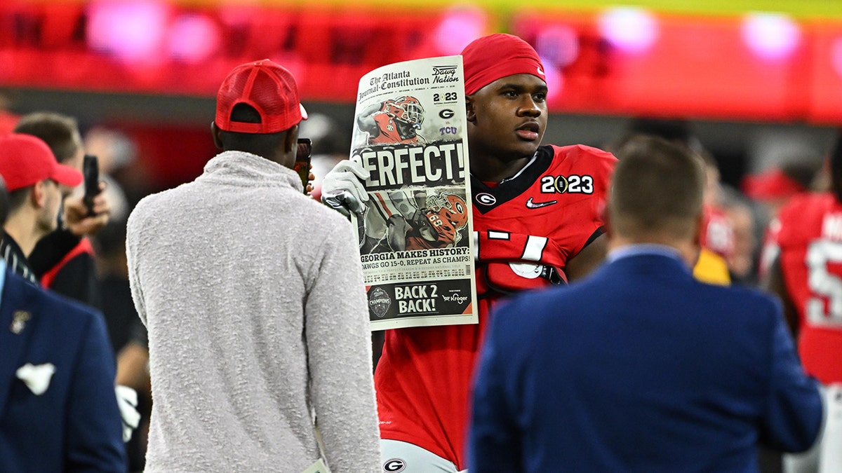 Devin Willock holds up a newspaper