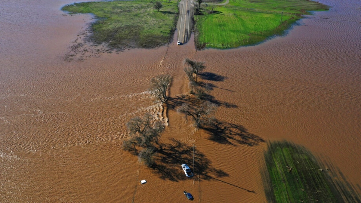 Vehicles submerged on a California road after levee breaks