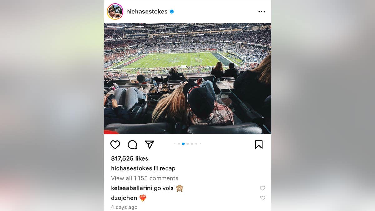 Chase Stokes Instagram of him in a football stadium, backs turned to camera, he is wearing a flannel shirt and Kelsea Ballerini is cozied up next to him