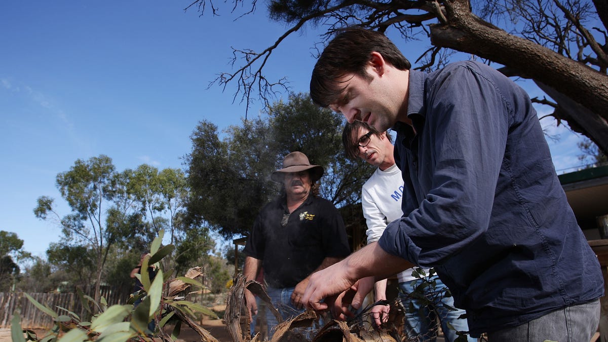 World's top chef Rene Redzepi, of Danish restaurant Noma checks a kangaroo being cooked on an open bush fire oven during a visit to the Iga Warta indigenous community in the South Australian Outback.