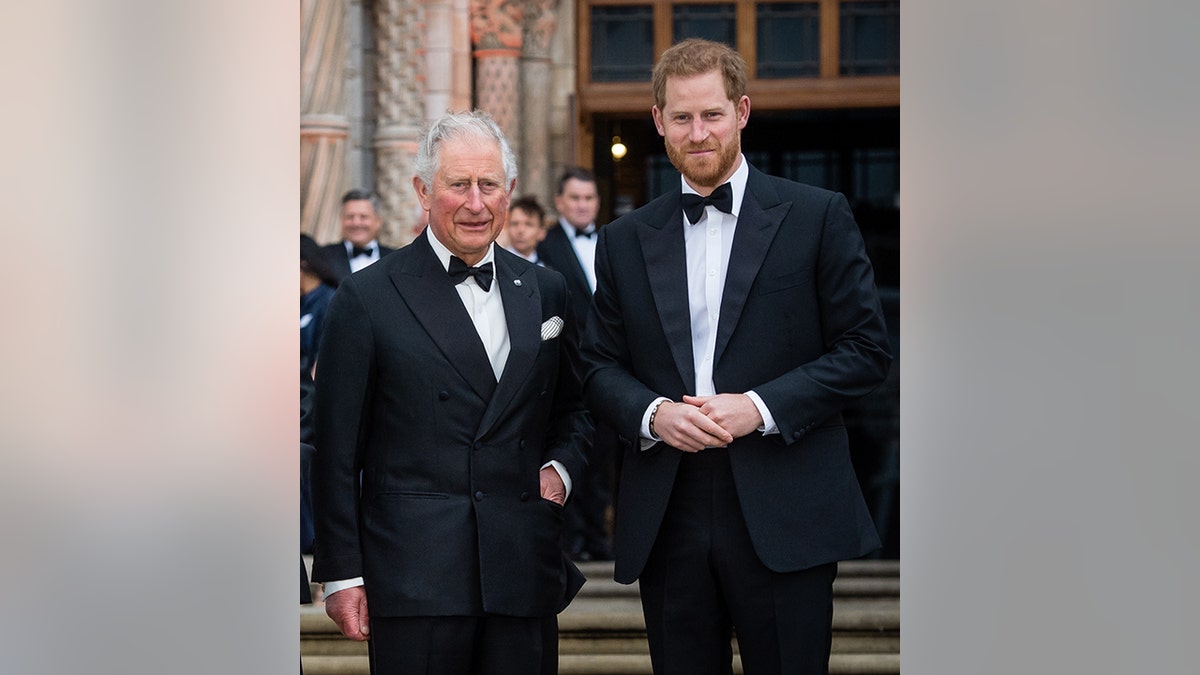 King Charles in a tuxedo poses with his son Prince Harry on the steps of the National History Museum in 2019