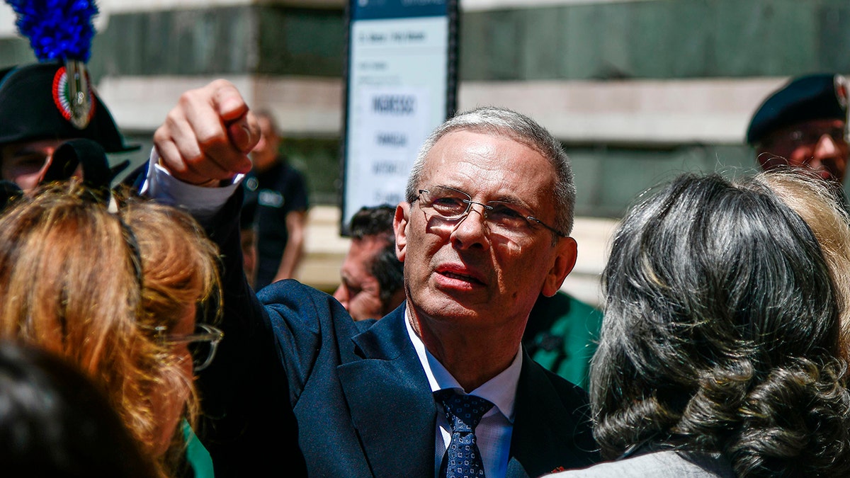 Pippo Zeffirelli attends his father's funeral in 2019 and gestures at something afar